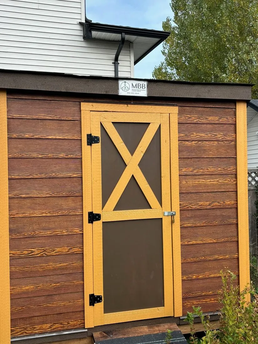 Cedar-look shed with yellow X-brace door