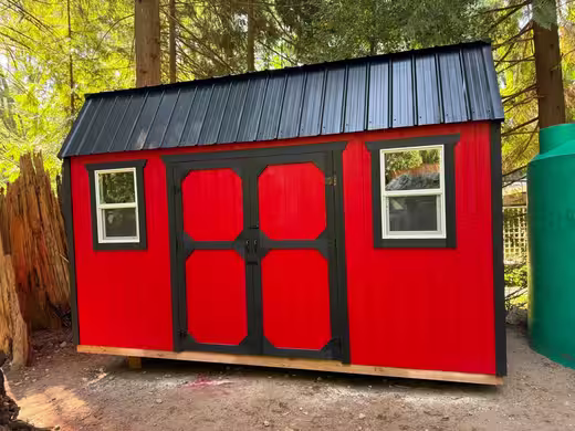 Red barn shed in the trees, photo 1 of 4