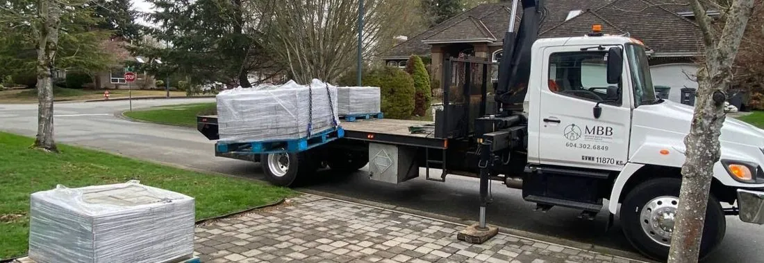 Crane truck on a residential street carrying a load